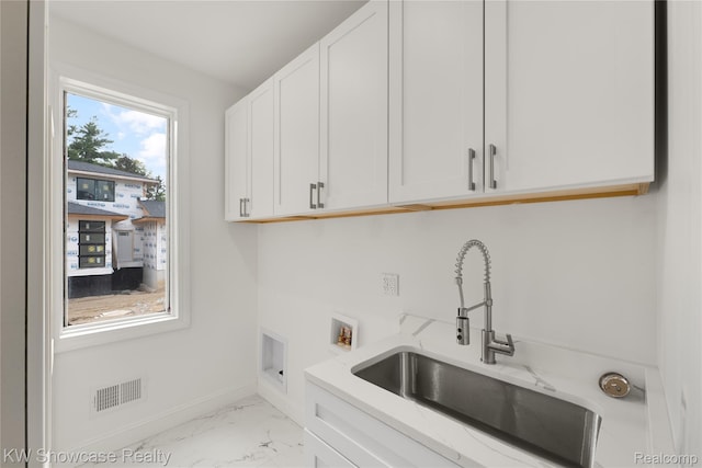 5245 Buell Dr, Commerce Twp, MI 48382 - laundry area with cabinet space, marble look tiles, baseboards, and washer hookup