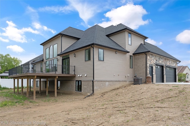 5245 Buell Dr, Commerce Twp, MI 48382 - view of home's exterior with an attached garage, central AC, a deck, a shingled roof, and driveway