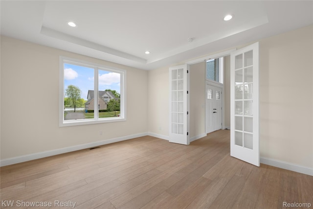 5245 Buell Dr, Commerce Twp, MI 48382 - spare room with french doors, a tray ceiling, light wood-type flooring, baseboards, and recessed lighting