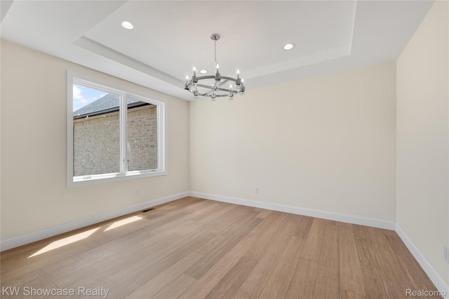 5245 Buell Dr, Commerce Twp, MI 48382 - unfurnished room featuring a chandelier, a raised ceiling, light wood finished floors, recessed lighting, and baseboards