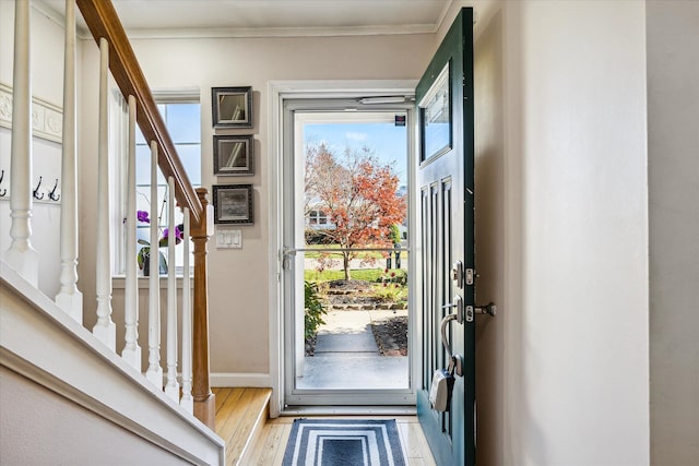 foyer featuring crown molding and light hardwood / wood-style flooring