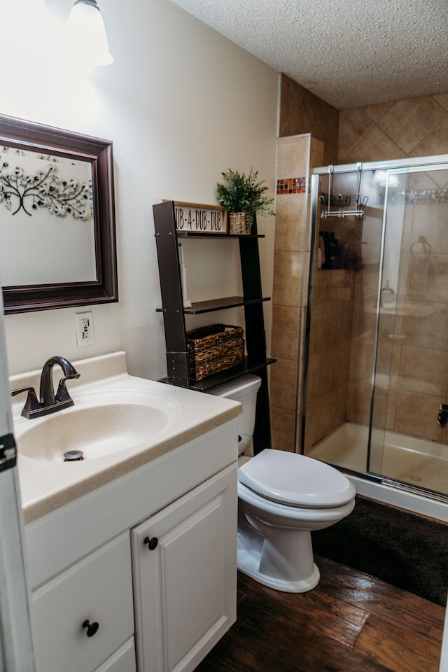 bathroom with toilet, an enclosed shower, vanity, and hardwood / wood-style floors