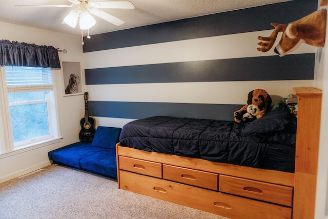 bedroom featuring a textured ceiling, ceiling fan, carpet, and multiple windows