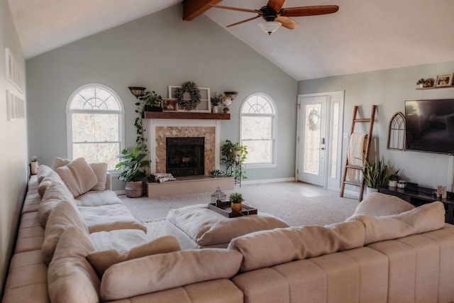 carpeted living room with a high end fireplace, ceiling fan, and lofted ceiling with beams