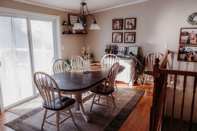 dining room with light wood-type flooring and crown molding