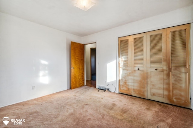 unfurnished bedroom with carpet flooring and a closet