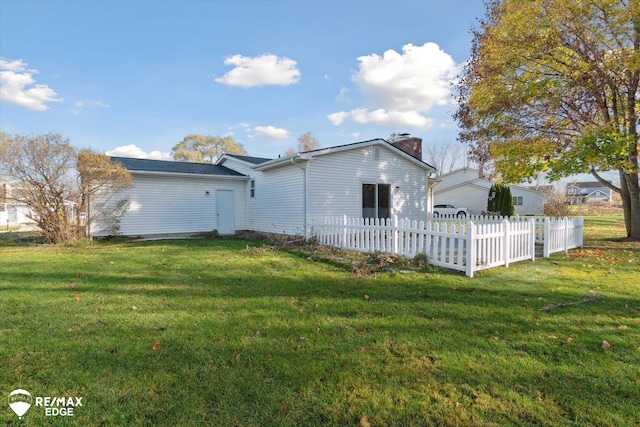 rear view of property with a lawn