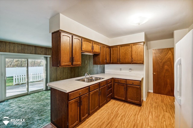 kitchen with white fridge, light wood-type flooring, and sink