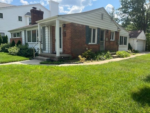 view of front of property with a front yard and an outdoor structure