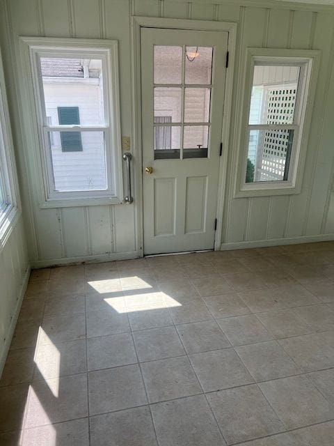 doorway to outside with light tile patterned flooring