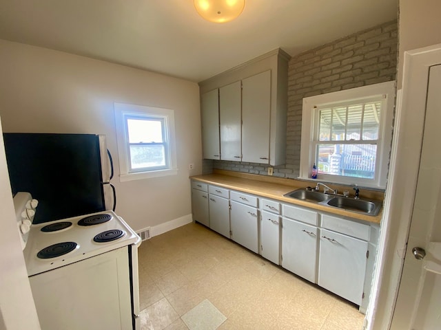 kitchen featuring white range with electric cooktop, white cabinets, sink, and refrigerator