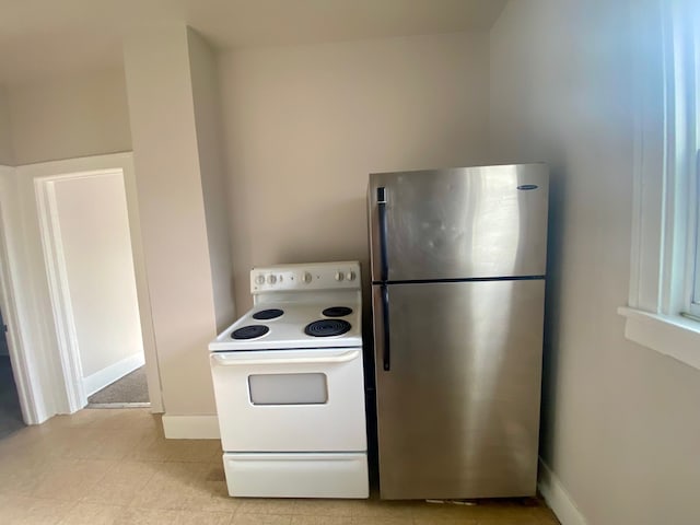 kitchen with white range with electric cooktop and stainless steel refrigerator