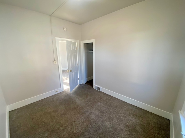 empty room with dark colored carpet