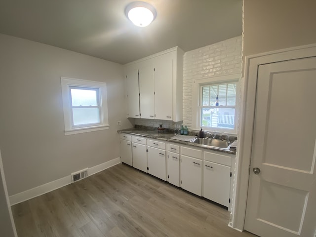 kitchen featuring visible vents, a sink, white cabinetry, and a healthy amount of sunlight
