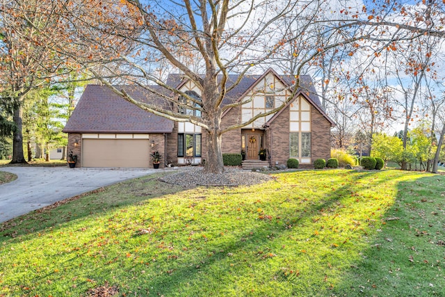 tudor-style house featuring a front lawn and a garage