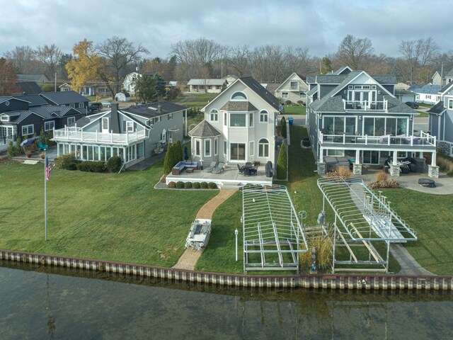 back of house featuring a patio, a balcony, and a water view