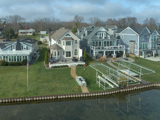 back of property with a patio area, a balcony, and a water view