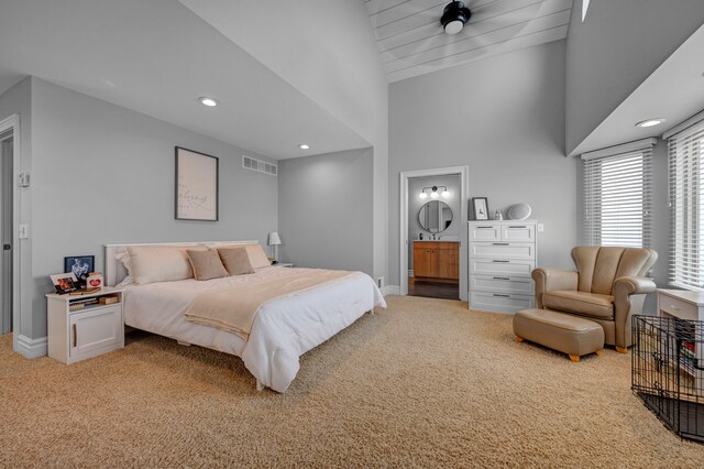 carpeted bedroom featuring connected bathroom and high vaulted ceiling