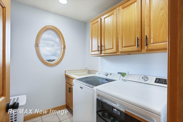 washroom featuring light tile patterned flooring, independent washer and dryer, cabinets, and sink