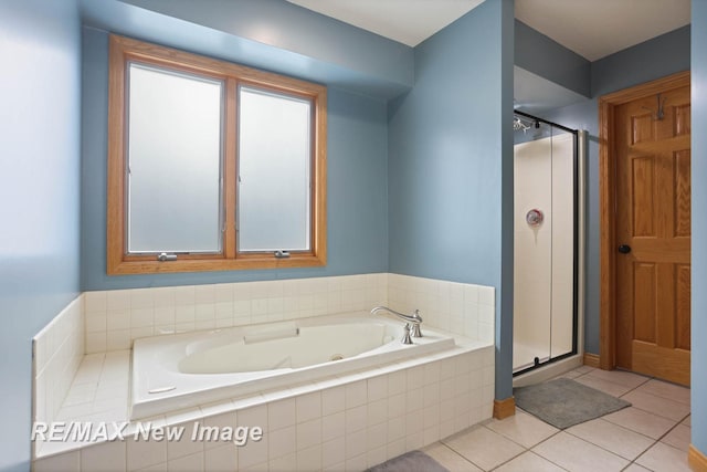 bathroom with separate shower and tub and tile patterned flooring