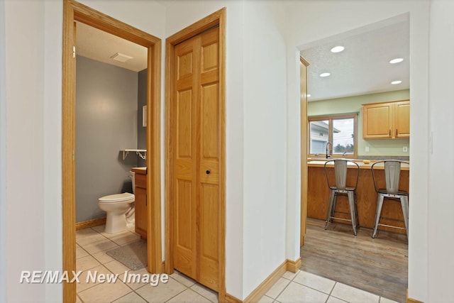 bathroom featuring toilet, tile patterned floors, and sink