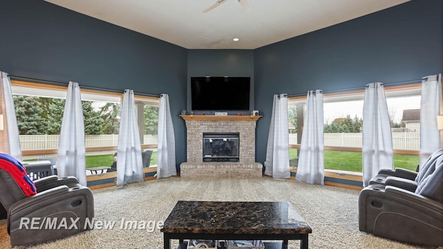 living room with carpet flooring, a wealth of natural light, and a fireplace