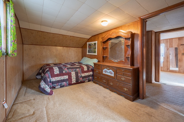 carpeted bedroom with multiple windows, lofted ceiling, and wood walls