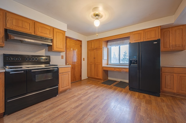 kitchen with black appliances and light hardwood / wood-style floors