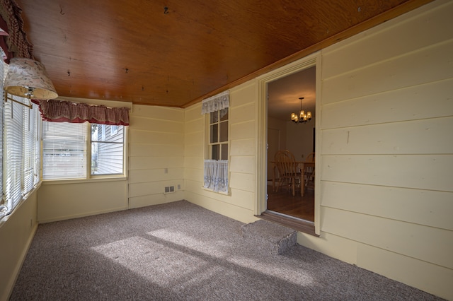 unfurnished sunroom featuring a notable chandelier and wood ceiling