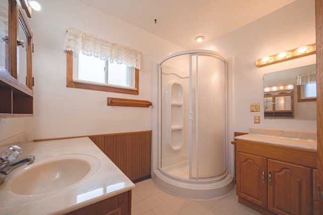 bathroom featuring tile patterned flooring, vanity, and a shower with door