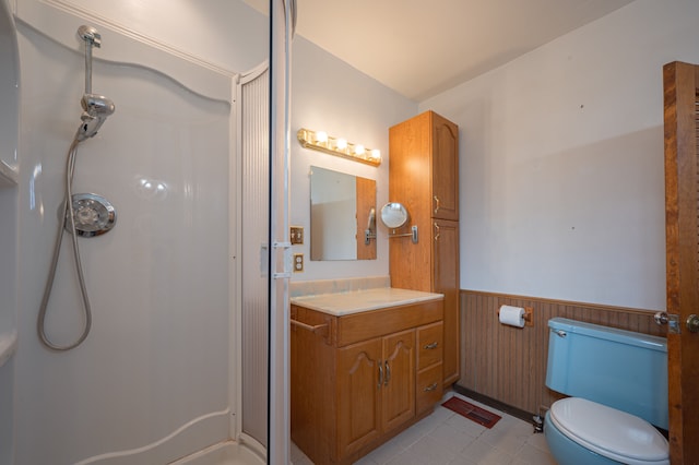 bathroom featuring vanity, wood walls, tile patterned flooring, toilet, and walk in shower