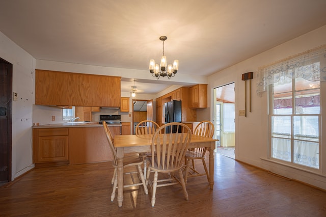 dining room featuring hardwood / wood-style flooring, sink, and an inviting chandelier