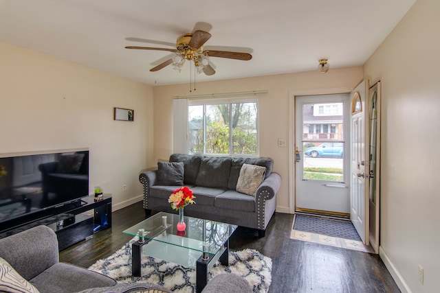 living room with ceiling fan and dark wood-type flooring