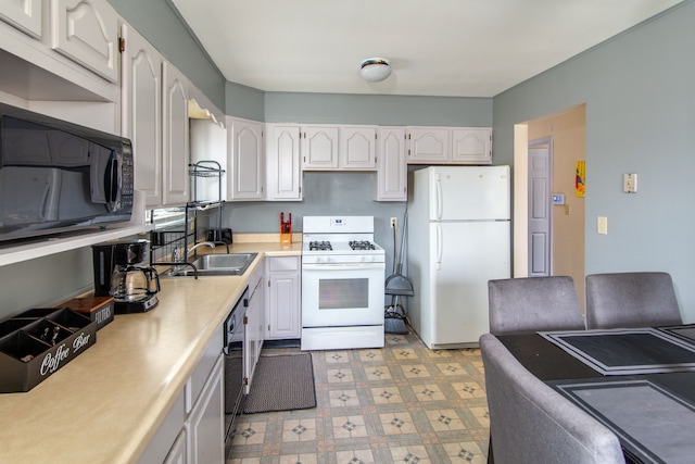 kitchen with black appliances, white cabinets, and sink