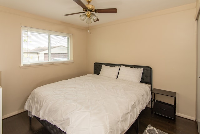 bedroom with ceiling fan, dark hardwood / wood-style floors, and ornamental molding