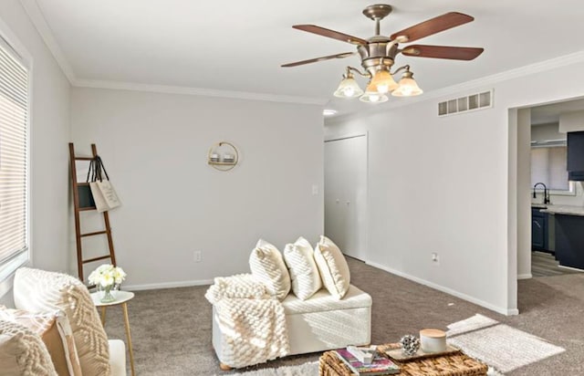 living room featuring a healthy amount of sunlight, carpet floors, ornamental molding, and sink