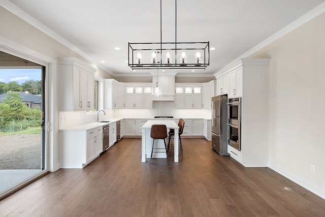 kitchen with dark hardwood / wood-style floors, a kitchen island, white cabinetry, and appliances with stainless steel finishes