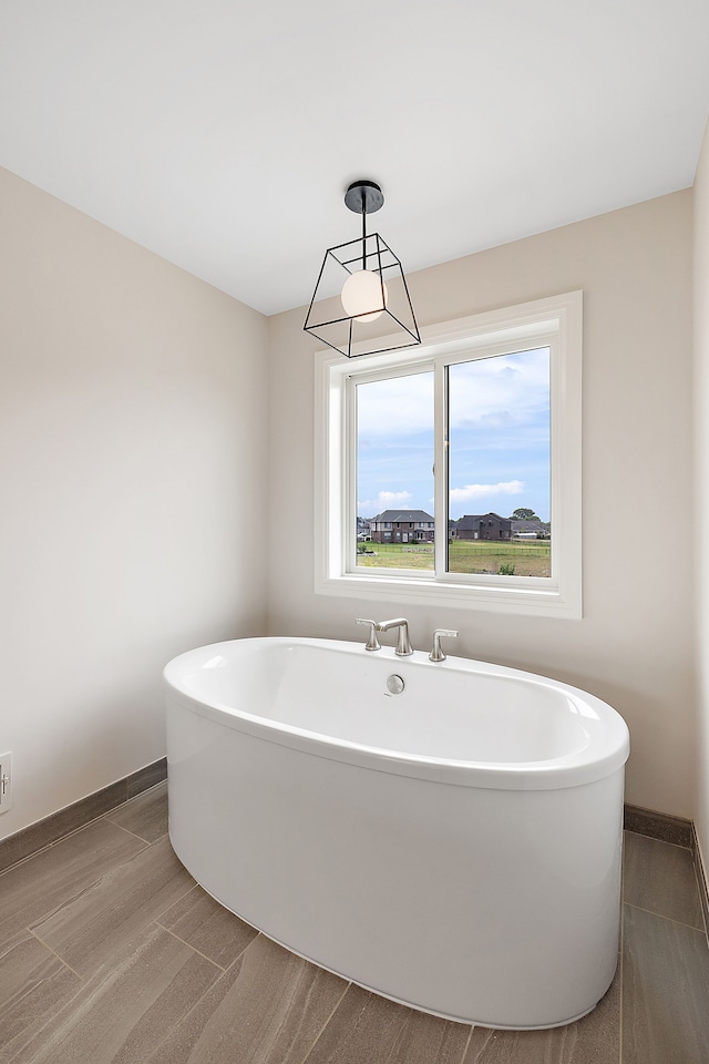 bathroom with a tub to relax in and hardwood / wood-style floors