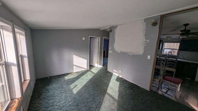 empty room with carpet, vaulted ceiling, and ceiling fan