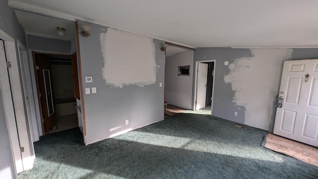 carpeted empty room with lofted ceiling