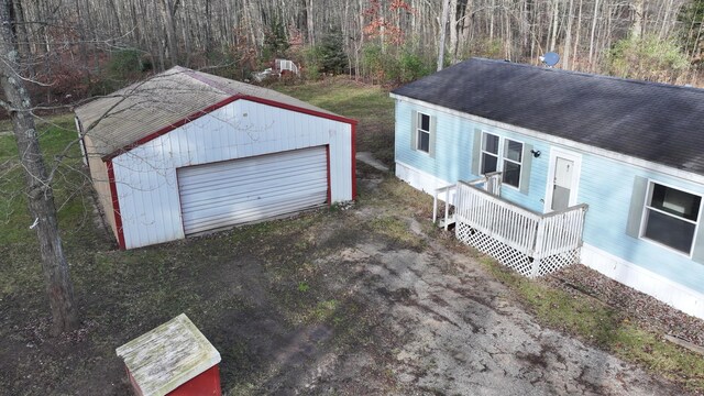 6259 N Custer Rd, Michigan, MI 49411 - detached garage with a porch and a wooded view