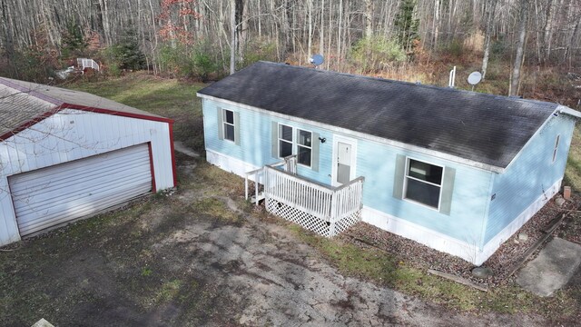 6259 N Custer Rd, Michigan, MI 49411 - manufactured / mobile home featuring an outbuilding, roof with shingles, crawl space, a porch, and a wooded view