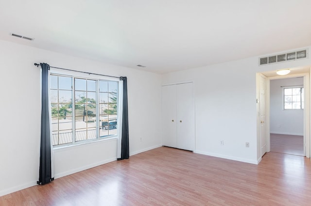 unfurnished room featuring plenty of natural light and light hardwood / wood-style floors