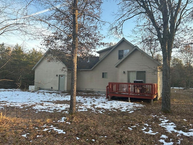 snow covered back of property featuring a deck