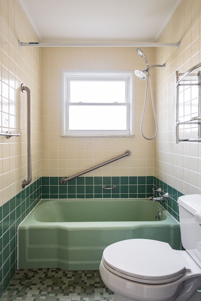 bathroom featuring tiled shower / bath, ornamental molding, tile walls, and toilet