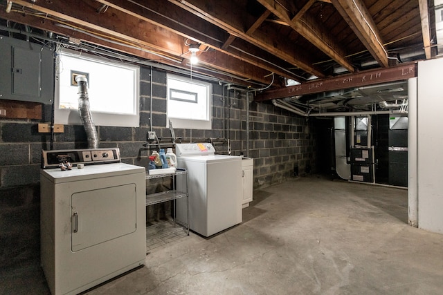 basement featuring washing machine and dryer, electric panel, and heating unit