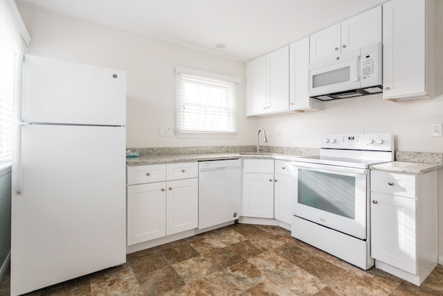 kitchen featuring white cabinetry, sink, light stone counters, and white appliances