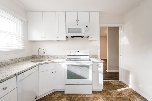 kitchen featuring white cabinets, white appliances, light stone countertops, and sink