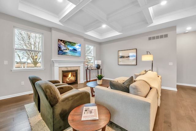 living room with hardwood / wood-style flooring, beamed ceiling, coffered ceiling, and a tiled fireplace