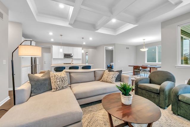 living room featuring beam ceiling, crown molding, and coffered ceiling